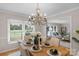 Elegant dining room with a chandelier, hardwood floors, and a view to the backyard and living area at 1607 Old Lawyers Rd, Marshville, NC 28103