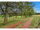 A scenic driveway leads to a beautiful property, lined with trees and a charming fence at 1607 Old Lawyers Rd, Marshville, NC 28103