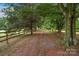 A scenic driveway leads to a beautiful property, lined with mature trees and a wooden fence at 1607 Old Lawyers Rd, Marshville, NC 28103