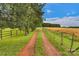 A scenic driveway leads to a beautiful property, lined with trees and a charming fence at 1607 Old Lawyers Rd, Marshville, NC 28103