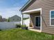 View of a backyard with a lush lawn, a covered patio, and a white fence at 170 Atwater Landing Dr, Mooresville, NC 28117