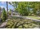 Large backyard featuring an artificial turf putting green, patio, and mature trees, perfect for outdoor activities at 1726 The Plz, Charlotte, NC 28205