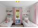Shared bedroom featuring twin beds, open shelving, and pink curtains at 1726 The Plz, Charlotte, NC 28205