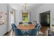 Dining room featuring shiplap walls, a wooden table, blue chairs, and natural light at 1726 The Plz, Charlotte, NC 28205