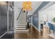 Bright foyer with hardwood floors, stairs, stylish light fixture and blue patterned wallpaper at 1726 The Plz, Charlotte, NC 28205