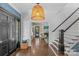 Elegant foyer with hardwood floors, stairs, a large pendant light and black door at 1726 The Plz, Charlotte, NC 28205