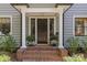 Inviting front entrance with brick steps, white columns, and elegant potted plants at 1726 The Plz, Charlotte, NC 28205
