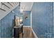 Hallway with stylish wallpaper, hardwood floors, a black console table and stairs nearby at 1726 The Plz, Charlotte, NC 28205