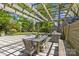 Covered outdoor dining area with a large table, wicker chairs, and a built-in grill station at 1726 The Plz, Charlotte, NC 28205