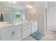 Bathroom with double sinks, white cabinets, a large mirror, and modern lighting at 190 Tetcott St, Mooresville, NC 28115
