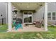 Cozy covered patio area with outdoor seating, grill, and a door to the house at 190 Tetcott St, Mooresville, NC 28115
