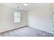 A simple bedroom with neutral carpet, one window, and crisp white walls at 2012 Embassy Ct # 46, Charlotte, NC 28213