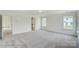 Large bedroom with three windows providing natural light, neutral carpeting, and adjacent bathroom at 2012 Embassy Ct # 46, Charlotte, NC 28213