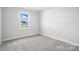 Simple bedroom featuring neutral paint, carpet, base trim, and a window at 2012 Embassy Ct # 46, Charlotte, NC 28213