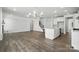 Open-concept living area with hardwood floors, a staircase, and a modern kitchen featuring a center island at 2012 Embassy Ct # 46, Charlotte, NC 28213