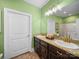 Bathroom with double sinks, granite countertops, dark wood cabinets, and green painted walls at 206 Montclair Dr, Locust, NC 28097