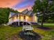 Inviting exterior showcases a well-lit home with a large porch, landscaped yard and elegant architectural details at 206 Montclair Dr, Locust, NC 28097