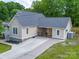 An elevated view of a cozy home featuring stone accents and a long driveway at 206 Montclair Dr, Locust, NC 28097