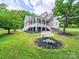 Inviting exterior featuring a welcoming front porch, well-manicured lawn, and lush greenery at 206 Montclair Dr, Locust, NC 28097