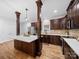 Well-lit kitchen featuring dark wood cabinetry, stainless steel appliances, and a quartz countertop island at 206 Montclair Dr, Locust, NC 28097