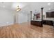 Open-concept kitchen and living room with hardwood floors and modern light fixtures at 206 Montclair Dr, Locust, NC 28097
