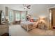 Bright bedroom featuring a ceiling fan, bay window with shutters, and adjacent desk space at 2119 Augusta National Dr, Denver, NC 28037