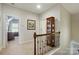 Upstairs hallway with wooden railing, neutral carpet, and access to rooms at 2119 Augusta National Dr, Denver, NC 28037