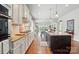 Open-concept kitchen boasts granite countertops, modern appliances, and wood floors at 2119 Augusta National Dr, Denver, NC 28037