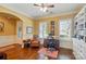 Bright office featuring custom built-ins, hardwood floors, and large windows with plantation shutters at 2119 Augusta National Dr, Denver, NC 28037