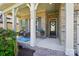 View of the front porch with brick columns and a seating area with blue patterned rug at 2119 Augusta National Dr, Denver, NC 28037