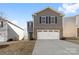 Charming two-story home featuring gray siding, brick accents, a two-car garage, and well-maintained landscaping at 2120 Redstone Dr, York, SC 29745