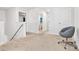 Upstairs hallway with neutral carpet, white walls, a gray rolling chair, and open doorways to other rooms at 2120 Redstone Dr, York, SC 29745