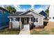 Inviting two-story gray home featuring fresh landscaping and a charming front porch with white stairs and railings at 2124 Roslyn Ave, Charlotte, NC 28208