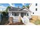Charming gray two-story home featuring brick accents, freshly mulched landscaping, and a welcoming front porch at 2124 Roslyn Ave, Charlotte, NC 28208