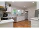 Bright kitchen boasts white cabinets, stainless steel appliances, and hardwood floors for a modern, clean look at 2124 Roslyn Ave, Charlotte, NC 28208