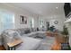 Spacious living room featuring a comfortable gray sectional, hardwood floors, and an open layout leading to the dining area at 2124 Roslyn Ave, Charlotte, NC 28208