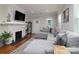 Inviting living room with a cozy gray sectional, white brick fireplace, and hardwood floors, perfect for relaxation at 2124 Roslyn Ave, Charlotte, NC 28208
