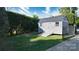 Exterior view of backyard storage shed with double doors and small ramp surrounded by green grass at 2124 Roslyn Ave, Charlotte, NC 28208