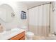 Well-lit bathroom with a round mirror, vanity, toilet, and shower with curtain at 2158 Winhall Rd, Fort Mill, SC 29715