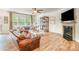 Cozy living room with wood floors, a fireplace, comfortable leather sofas, and plenty of natural light at 2158 Winhall Rd, Fort Mill, SC 29715