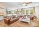 Open concept living area with wood floors, ceiling fan, lots of natural light, and stylish leather sofas at 2158 Winhall Rd, Fort Mill, SC 29715