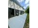 Wide, sunny backyard with a long concrete patio, bench, and a view of the home's exterior at 221 Belton Ave, Mount Holly, NC 28120