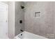 Modern bathroom boasts tiled walls, a shower with niche, and sleek fixtures at 221 Belton Ave, Mount Holly, NC 28120