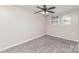 A bedroom with neutral walls, gray carpet, a ceiling fan, and a window at 221 Belton Ave, Mount Holly, NC 28120