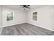 This is a well-lit bedroom, featuring neutral walls, two windows, and a ceiling fan at 221 Belton Ave, Mount Holly, NC 28120