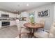 Cozy dining area with a round table, upholstered chairs, and a view of the updated kitchen at 221 Belton Ave, Mount Holly, NC 28120
