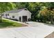 Home boasts an extended driveway leading to a garage, complemented by fresh landscaping at 221 Belton Ave, Mount Holly, NC 28120