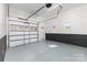 Clean garage with epoxy floors, painted block wall detail, garage door, and a service door at 221 Belton Ave, Mount Holly, NC 28120