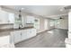 Open-concept kitchen and living space, featuring granite counters and sleek gray flooring at 221 Belton Ave, Mount Holly, NC 28120