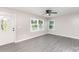 Inviting living room featuring stylish gray floors, plentiful natural light, and a modern ceiling fan at 221 Belton Ave, Mount Holly, NC 28120